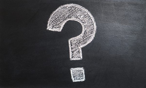 Chalk question mark on blackboard background.